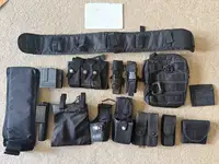 Assorted black tactical gear. Pouches, holsters belts etc.